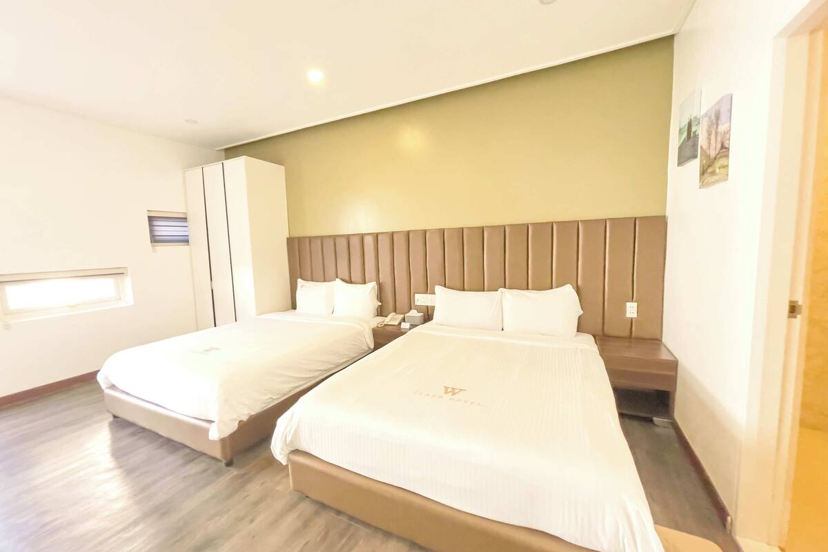 Een hotelkamer met twee bedden, een groot raam en een inloopkast.
