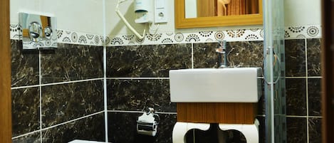 A bathroom with a toilet, sink, and mirror.
