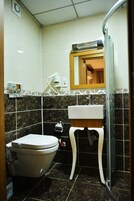 A bathroom with a toilet, sink, and mirror.
