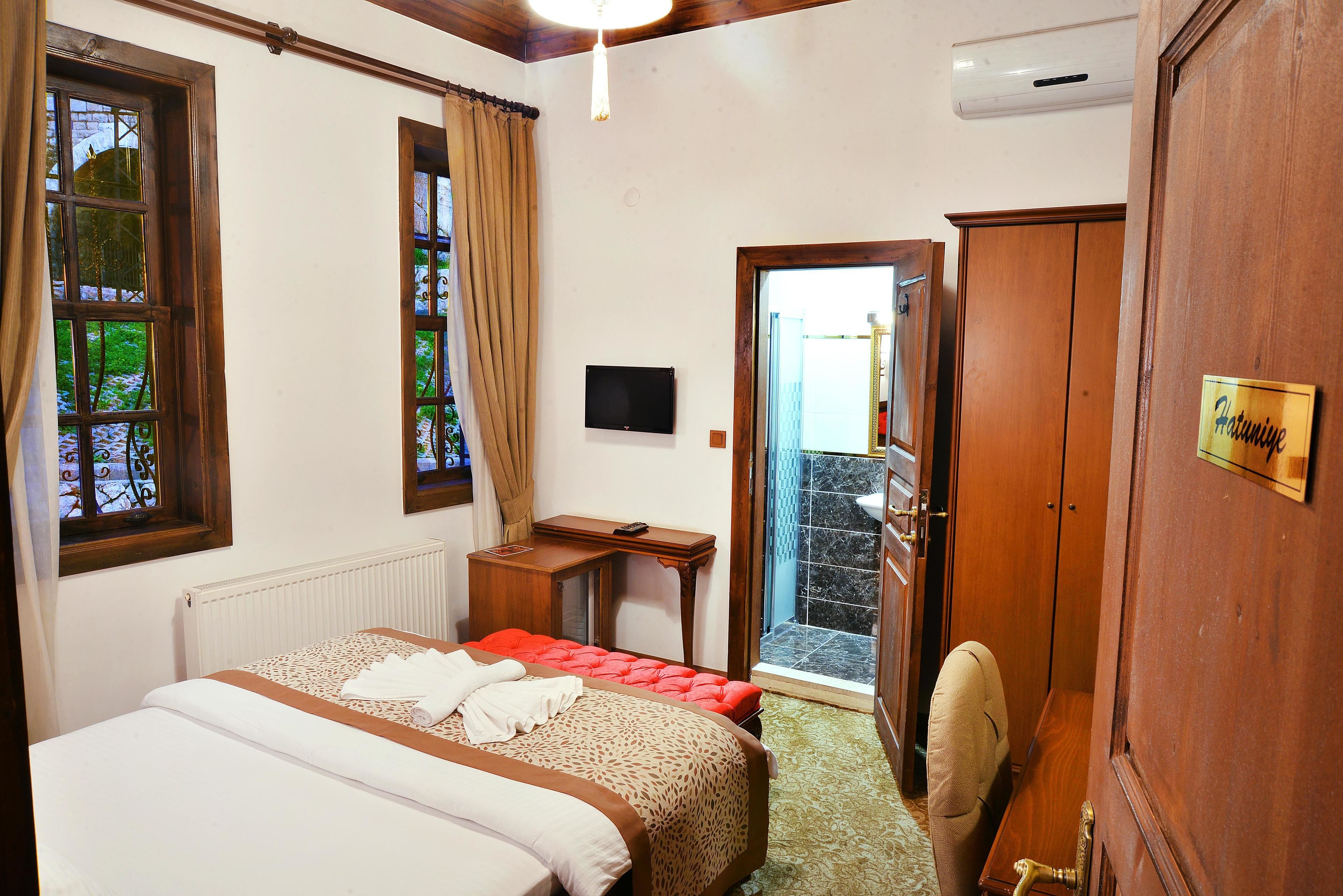Une chambre d’hôtel équipée d’un lit, d’un bureau, d’une télévision et d’une armoire.