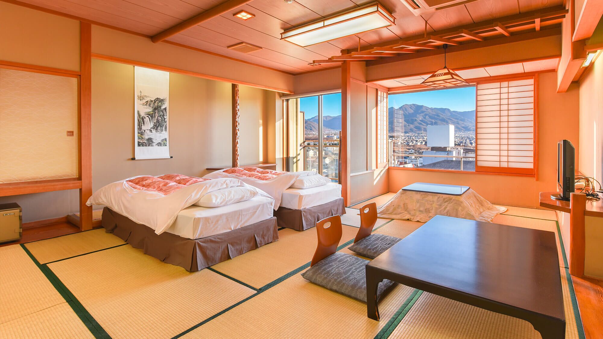 Ein traditionelles Hotelzimmer im japanischen Stil mit Tatami-Bodenbelag, zwei Betten, einem kleinen Tisch und Blick auf die Stadtlandschaft.