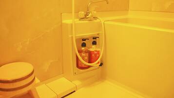 Un baño con inodoro, lavabo y zona de ducha.