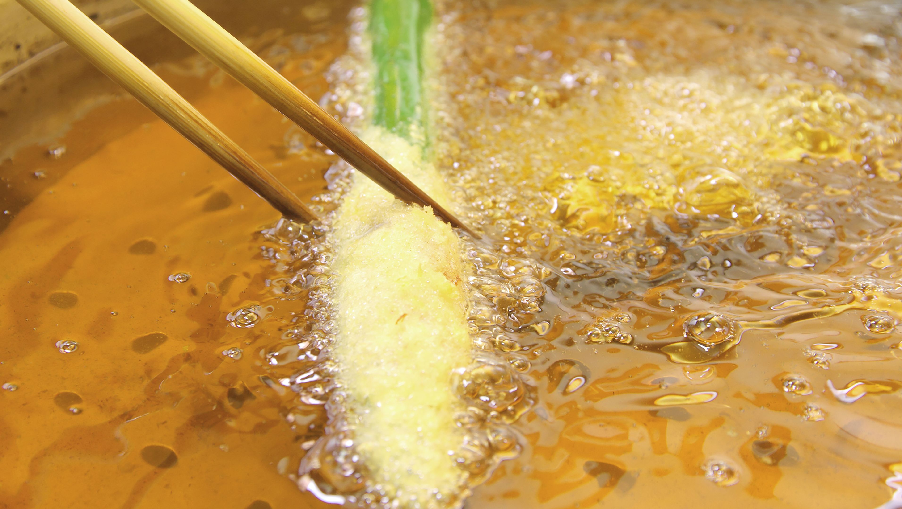 A close-up of food being fried in hot oil.