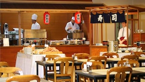 Ein Restaurant mit Holzvertäfelung, einem Buffet und Mitarbeitern in traditioneller Kleidung.