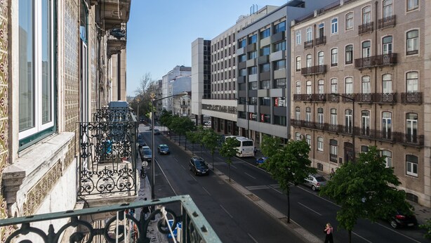 A street view with buildings, cars, and a pedestrian. - Hostel Seven Hills (Lisbon)