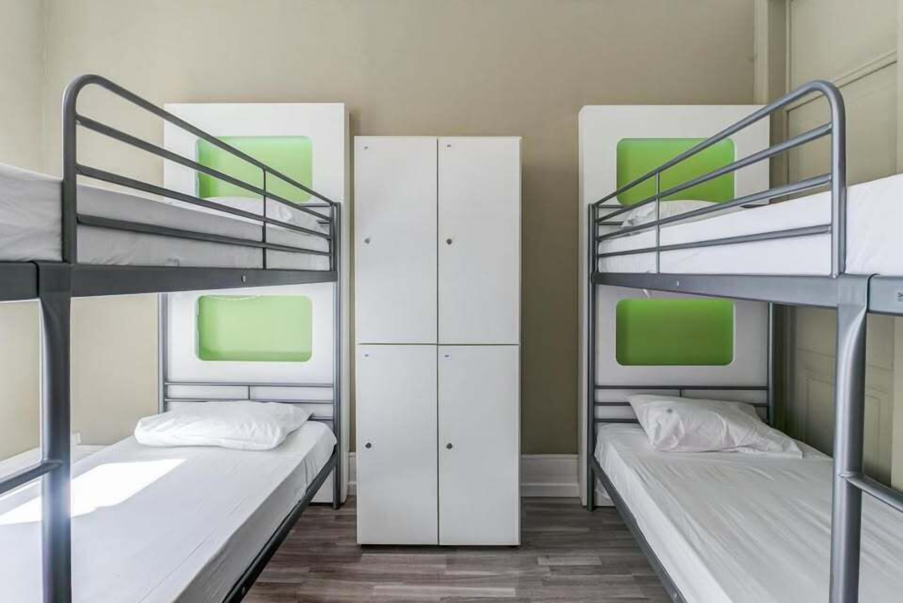 Un dormitorio con literas, un armario y una ventana.