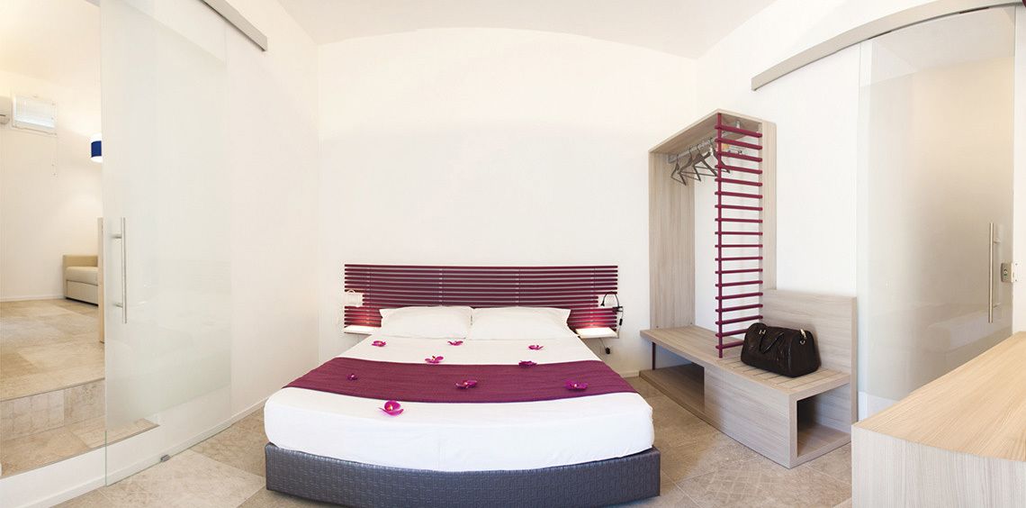A modern bedroom with a bed, bedside table, and a built-in wardrobe.