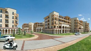 A multi-story hotel with a central courtyard, balconies, and a paved driveway. - Lighthouse Apartments & Villas (Balchik)