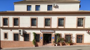 A two-story building with a sign reading "RESTAURANT" at the entrance. - Hotel Restaurante Casa Marchena (Vilches)