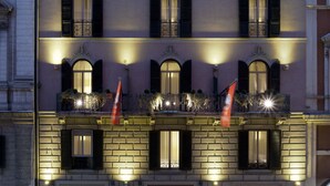 A multi-story hotel with a classic facade, multiple balconies, and a well-lit entrance. - Mascagni Luxury Rooms & Suites (Rome)
