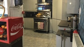 A modern kitchen with a built-in oven, a coffee machine, and a refrigerator. - Aquarius B&B (Newquay)