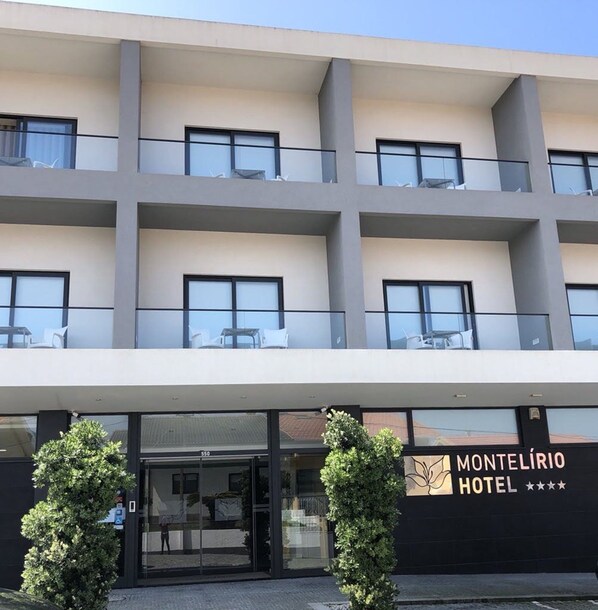 A hotel with a modern facade, multiple balconies, and a clear entrance.