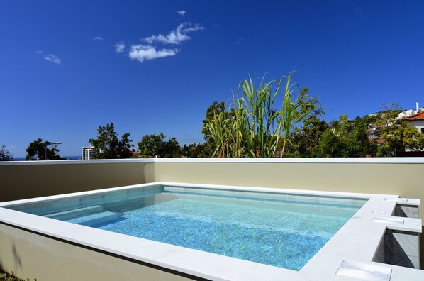 Piscine extérieure, parasols de plage, chaises longues