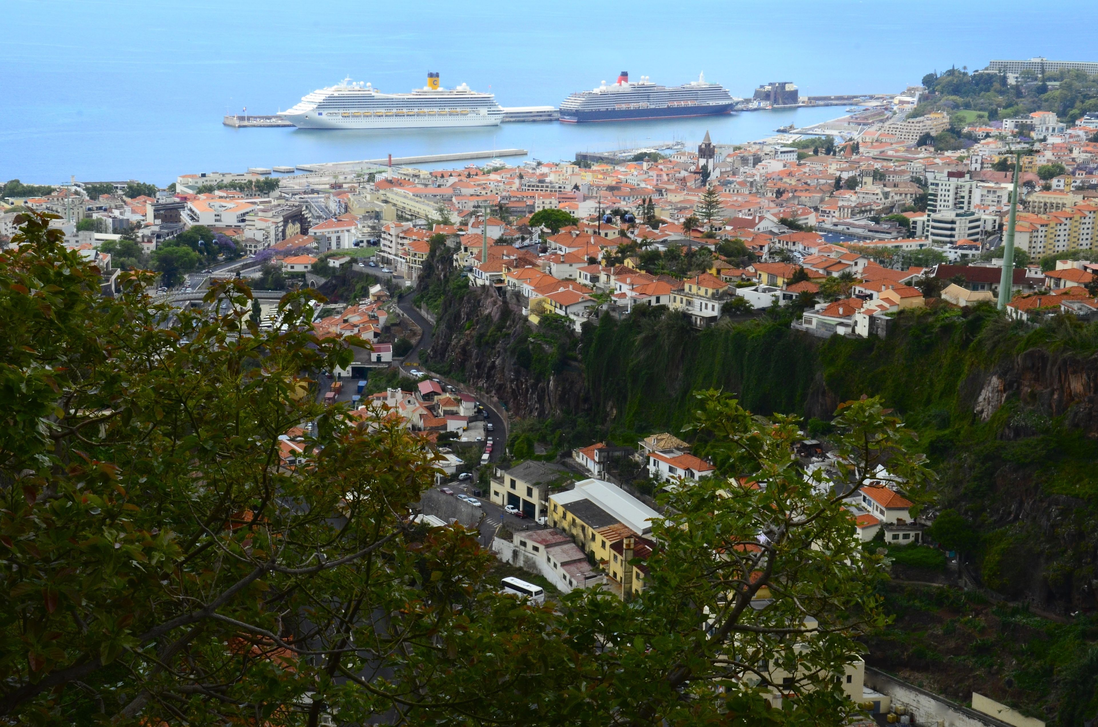 A coastal town with a view of three cruise ships docked at the port.