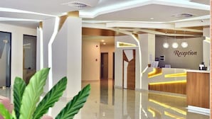 A modern reception area with a reception desk, a reception sign, and a clean, polished floor. - Hotel Grifid Foresta  Adults Only (Golden Sands)