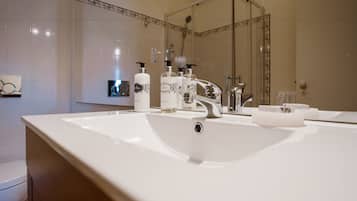 A modern bathroom with a large white sink, a mirror, and several toiletries.
