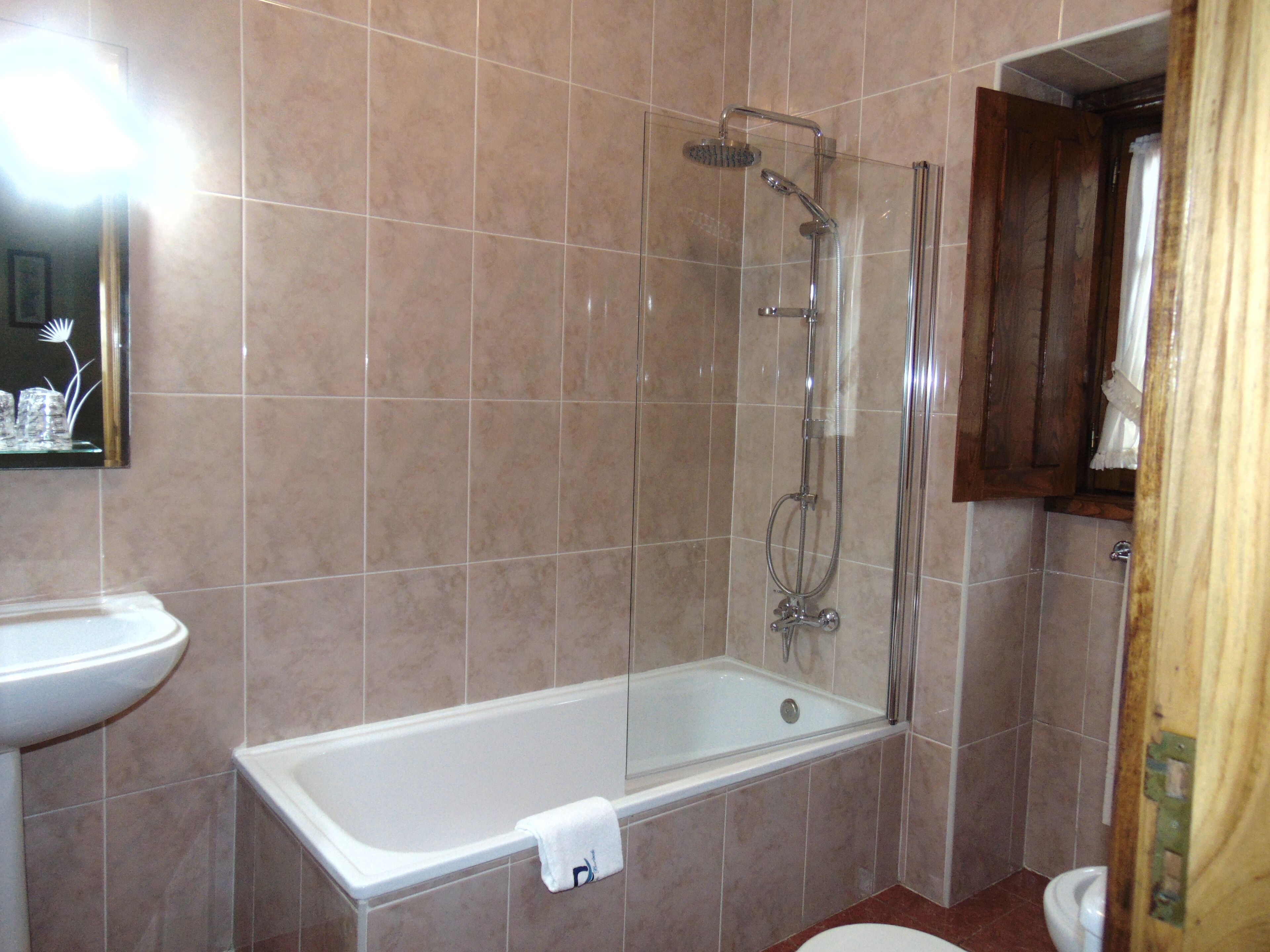 A bathroom with a bathtub, a shower, and a toilet.