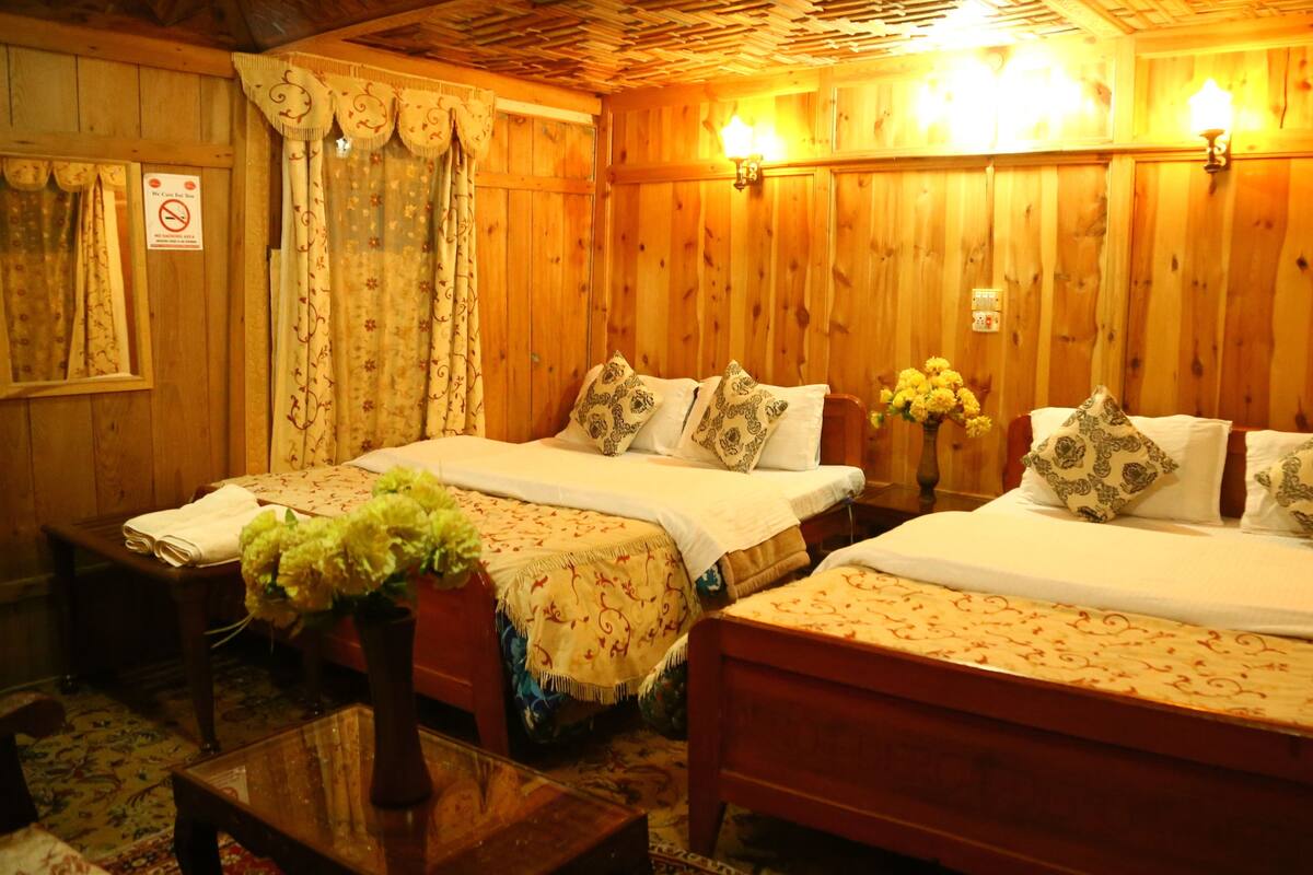 A wooden room with two beds, a small table, and a bench.