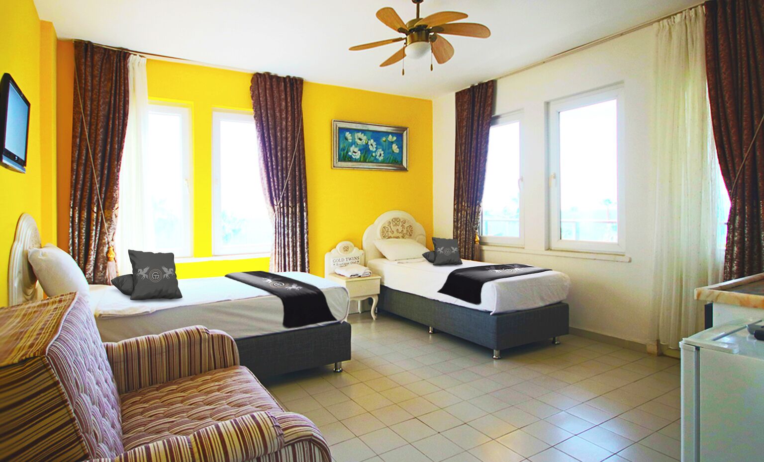 A hotel room with two beds, a desk, and a chair.