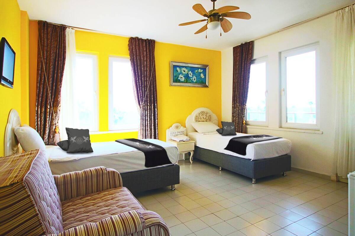 Ein Hotelzimmer mit zwei Betten, einem Schreibtisch und einem Stuhl.