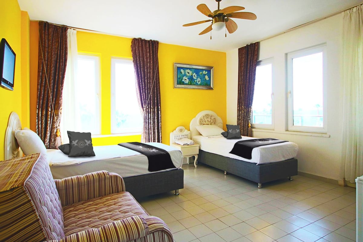 Une chambre d’hôtel avec deux lits, un bureau et une chaise.