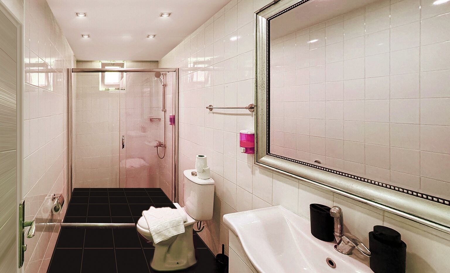 A modern bathroom with a shower, toilet, and sink.