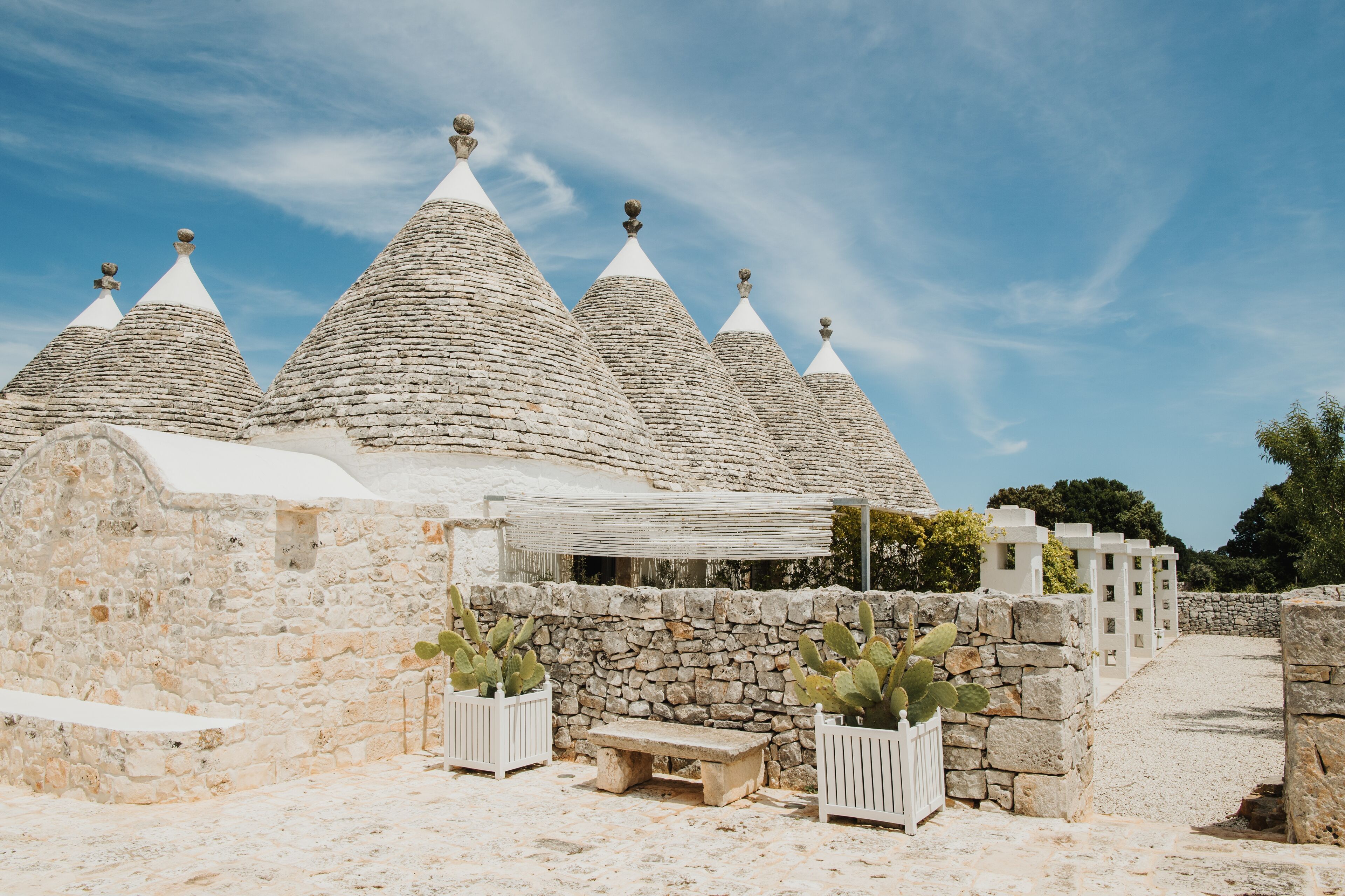 Un bâtiment en pierre avec des toits coniques et une clôture blanche.