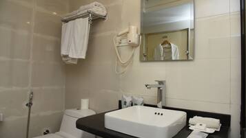 A bathroom with a white sink, a mirror, a towel rack, a hairdryer, and a toilet.