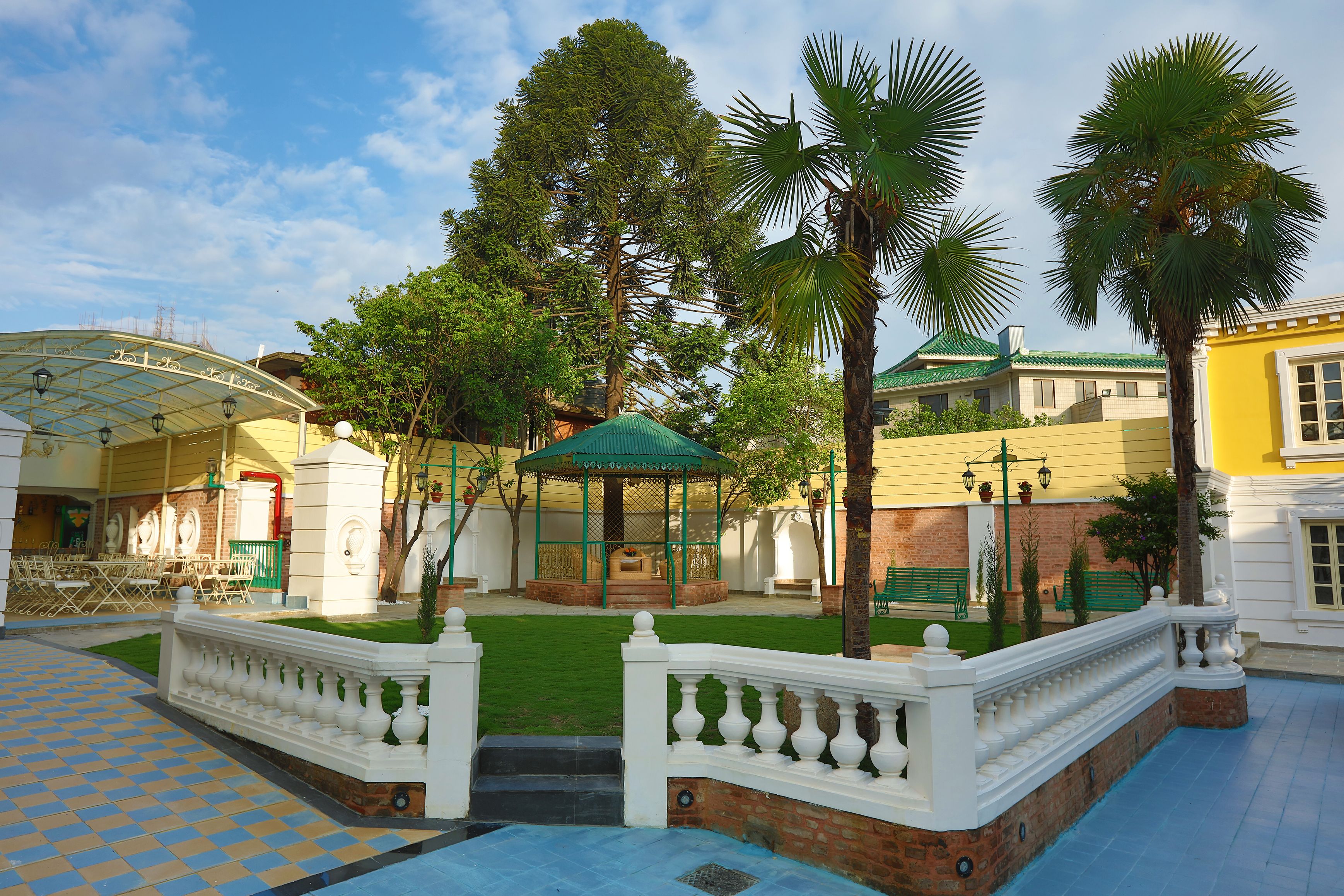 Un pati amb una zona coberta per seure, una piscina i un jardí ben cuidat.