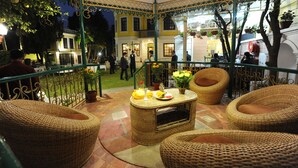 Un espace extérieur aménagé avec des meubles en osier et une table décorée de fleurs.