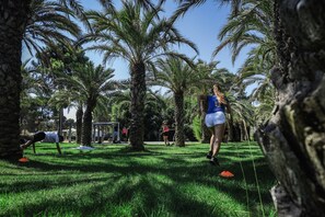 Un parque con palmeras y gente haciendo ejercicio.