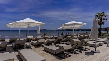 Vlak bij het strand, ligstoelen aan het strand, parasols