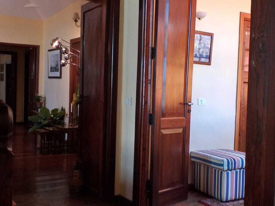 Ein Holzboden-Flur mit einer Bank, einer Tür und einer Wandleuchte.