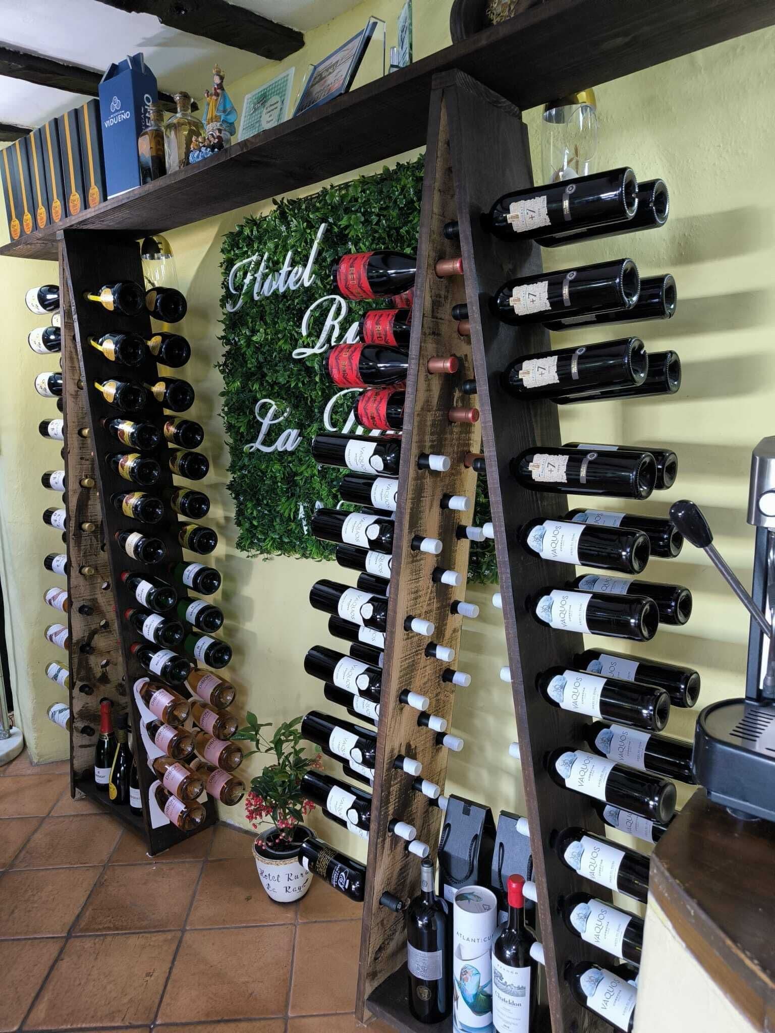 A wine rack with multiple bottles, a sign reading "Hotel La Casa," and a potted plant.