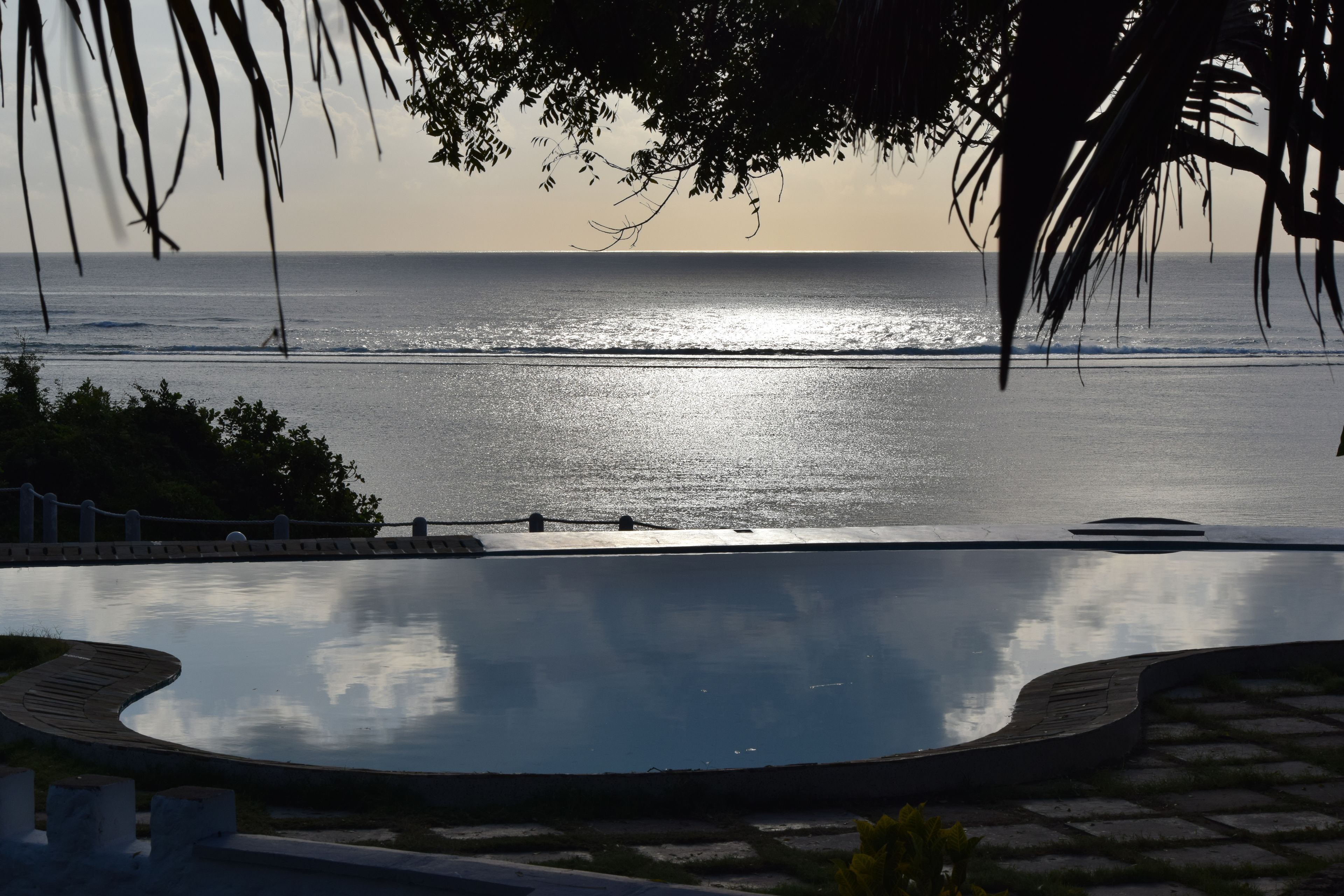 Une piscine avec vue sur l’océan et sur le coucher de soleil.