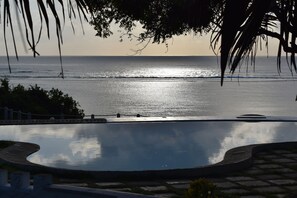 A swimming pool with a view of the ocean and a sunset. - HillPark Amare Resort (Tiwi)