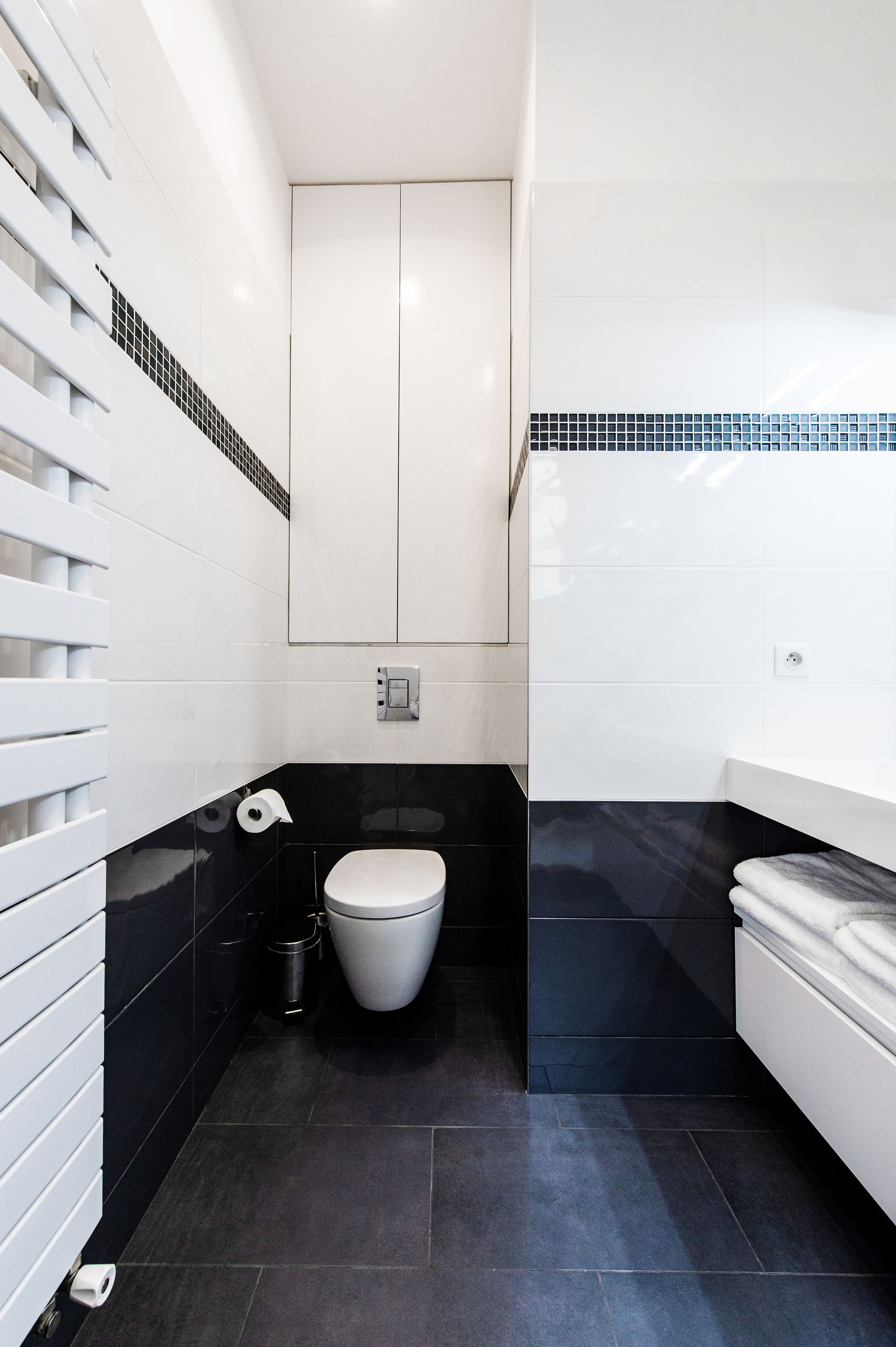 Une salle de bain moderne avec des toilettes, un lavabo et un miroir.