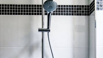 Een moderne douche met een handdouche en een vastgeplaatste douchekop, bevestigd aan een chroomdoucheset.
