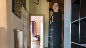 A hallway with wooden flooring, a radiator, and a bookshelf. - L'Albero di Gameli (Chiusi)