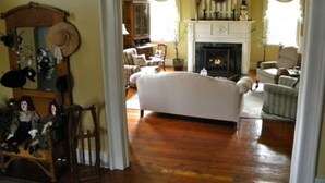 A traditional living room with a fireplace, wooden flooring, and classic furniture. - B&B at Oliver Phelps (Canandaigua)