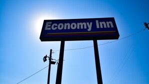 A sign for Economy Inn against a clear blue sky. - Economy Inn Beebe (Beebe)