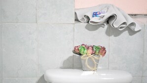 A toilet with a bouquet of flowers tied with a string.