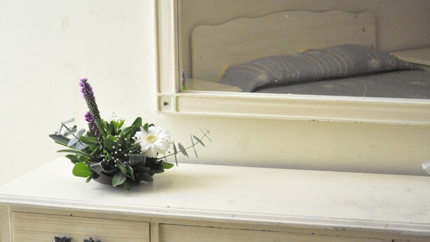 A white dresser with two drawers and a mirror above it.