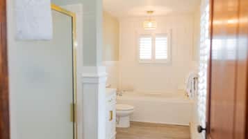 Een badkamer met toilet, wastafel en bad.