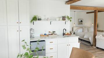 A modern kitchen with white cabinetry, a built-in dishwasher, and a breakfast bar.