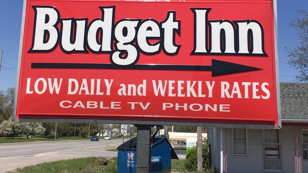 En skylt för Budget Inn som annonserar låga dags- och veckopriser, inklusive kabel-TV och telefontjänster.