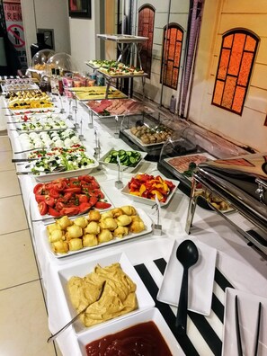 A buffet spread with various food items and condiments.