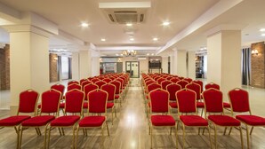 A conference room with rows of red chairs and a wooden floor. - Przystanek Toruń (Torun)