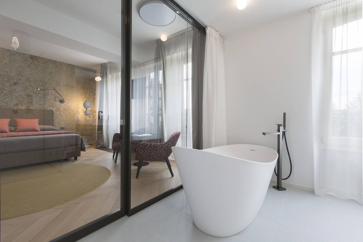 Et moderne badeværelse med et fristående badekar, en brusekabine i glas og et synligt toilet.