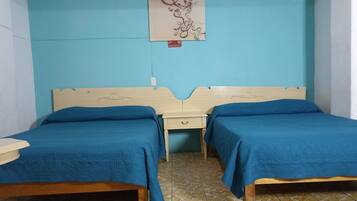 Une chambre avec deux lits, une petite table de chevet, un interrupteur fixé au mur et un élément décoratif au-dessus des lits.